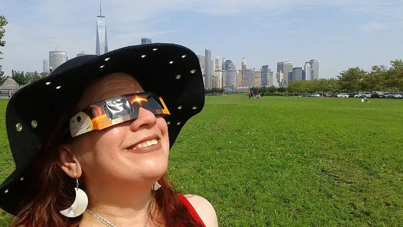 Personas mirando un eclipse solar con gafas de eclipse certificadas puestas