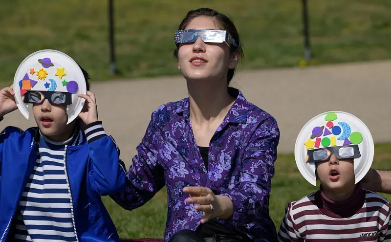 Personas mirando un eclipse solar con gafas de eclipse certificadas puestas