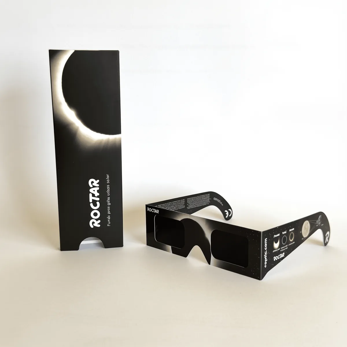 La funda ROCTAR de pie con la corona solar impresa y las gafas de eclipse ROPTIC delante