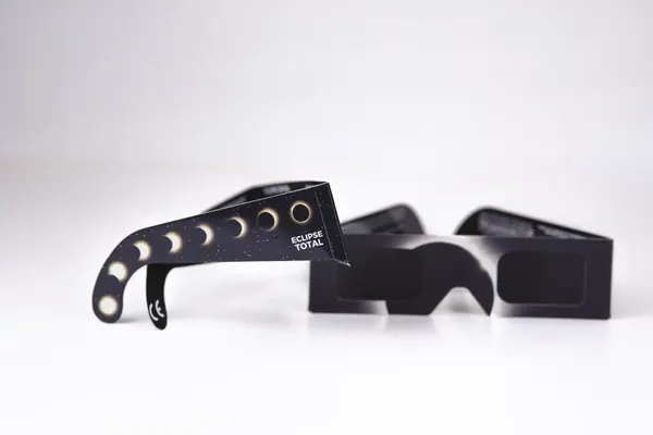 Detalle de la patilla de las gafas ROPTIC con la secuencia de fases del eclipse total impresa y el marcado CE
